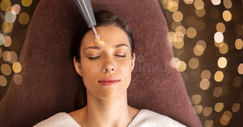 Mujer con el massager microcurrent de la cara en balneario fotografía de archivo Mujer con el massager microcurrent de la cara en balneario fotografía de archivo