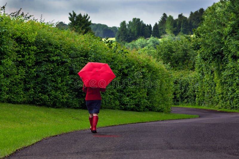 Mujer con el paraguas rojo en un día cubierto.