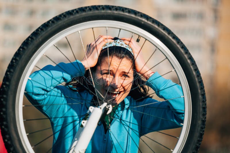 Mujer con el problema de la bici de la fijación del dolor de cabeza imagen de archivo libre de regalías Mujer con el problema de la bici de la fijación del dolor de cabeza imagen de archivo libre de regalías