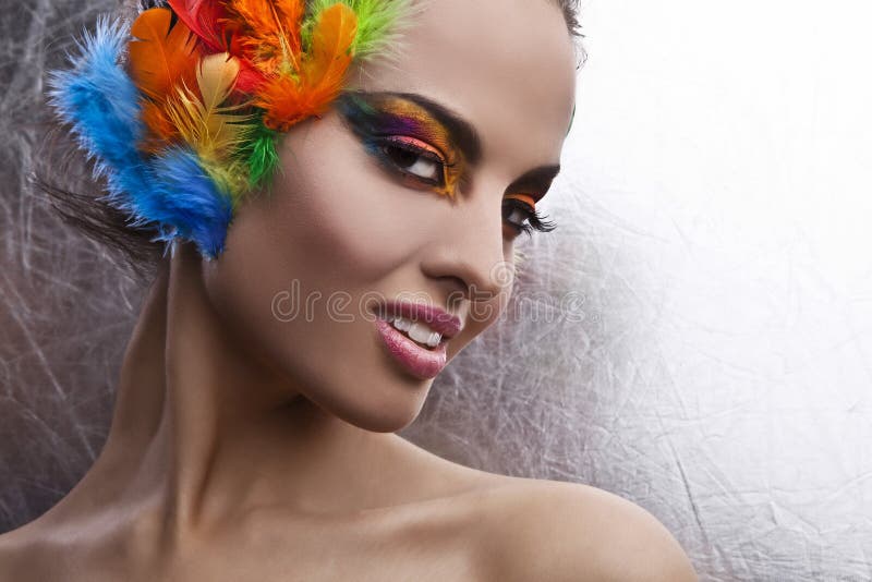  Mujer Con El Tocado Dramático Del Maquillaje Y De La Pluma Foto de archivo