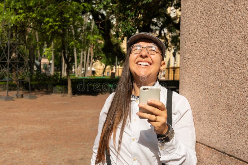 Mujer Gafas Redondas Mirando Hacia Arriba Y Sosteniendo Celular Smartphone. Al Aire Libre En Parque Y Bosques. Aplicación Imagen de archivo - Imagen de célula, gente: 215255671
