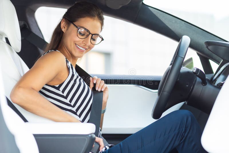 La mujer embarazada en el coche usando el cinturón de seguridad, vista  lateral Fotografía de stock - Alamy