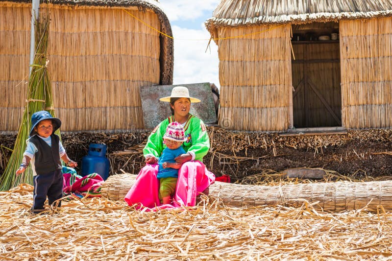 Mujer con los niños en las islas flotantes de Uros en el lago Titicaca foto de archivo libre de regalías Mujer con los niños en las islas flotantes de Uros en el lago Titicaca foto de archivo libre de regalías