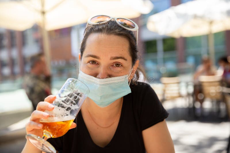 Mujer Con Máscara Protectora Disfrutando De La Cerveza En La Terraza Del Bar Al Libre Imagen de archivo - de realidad, alcohol: 191018041