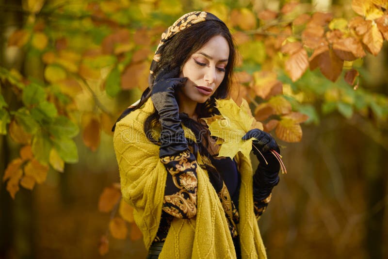 Mujer con manta disfruta el otoño y disfruta las hojas fotos de archivo libres de regalías