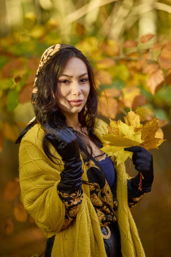 Mujer con manta disfruta el otoño y disfruta las hojas foto de archivo