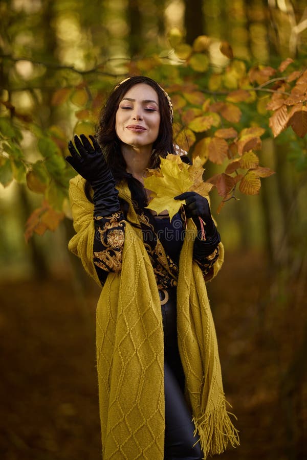 Mujer con manta disfruta el otoño y disfruta las hojas fotografía de archivo libre de regalías
