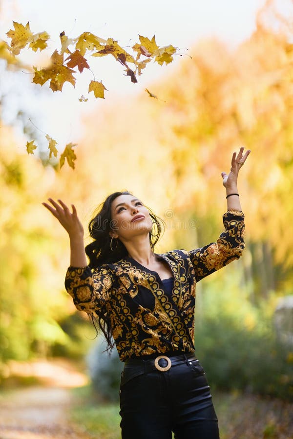 Mujer con manta disfruta el otoño y disfruta las hojas fotos de archivo libres de regalías