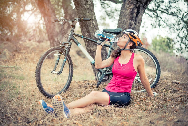 Mujer con su bici de montaña imagen de archivo Mujer con su bici de montaña imagen de archivo