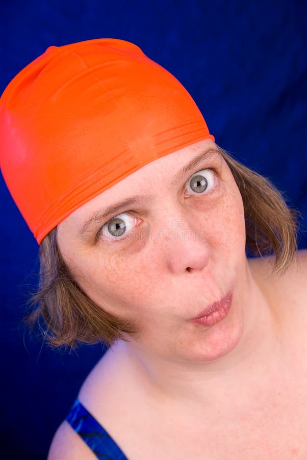 Woman with an orange swim cap making a funny faces. Woman with an orange swim cap making a funny faces