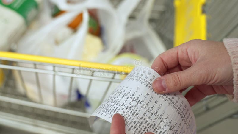 Mujer con un cheque de un supermercado. seguimiento y presupuestación de gastos