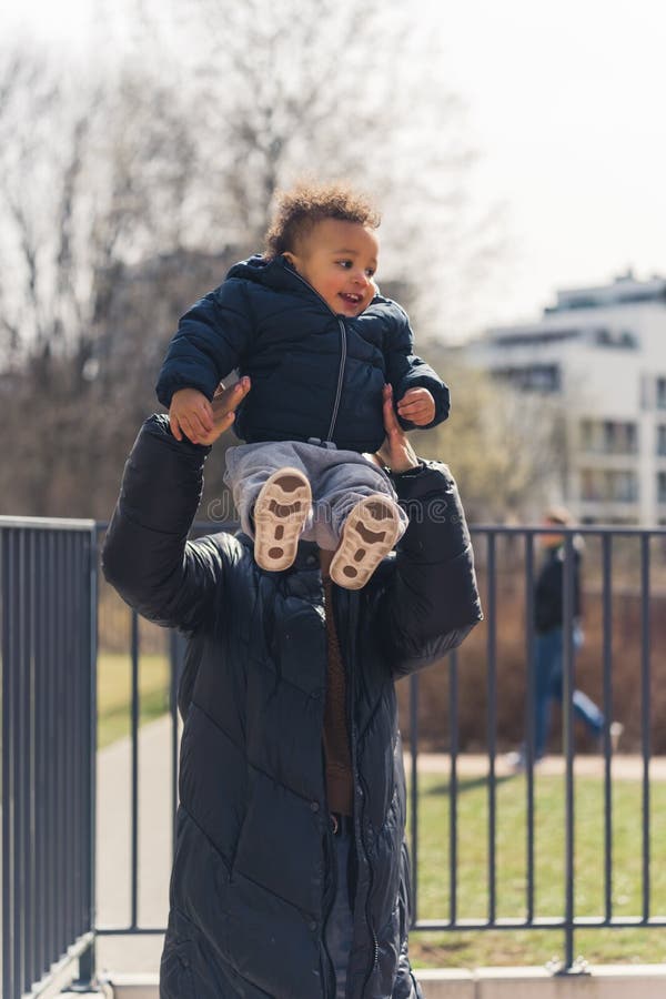 Mujer Un Largo Abrigo Negro Sosteniendo a Un Niño Afroamericano Rizado Que Vertical Afuera Foto de archivo - Imagen de mujeres, sonriente: 245248650