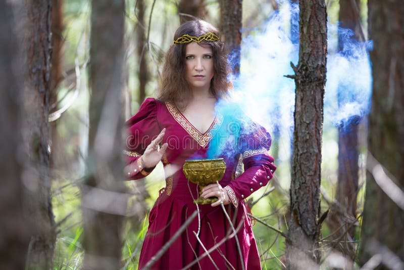 Mujer con vestido rojo que lanza un hechizo fotografía de archivo libre de regalías