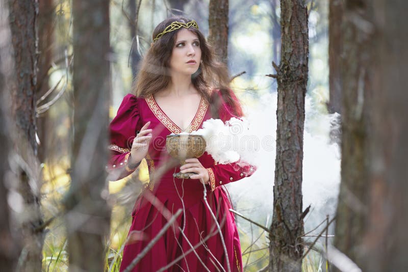 Mujer con vestido rojo que lanza un hechizo fotografía de archivo libre de regalías