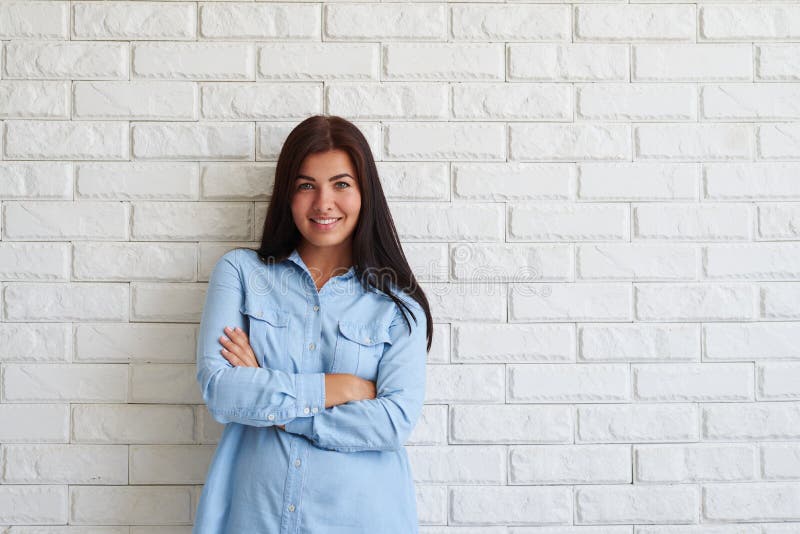 Mujer contenta feliz que sonríe con los brazos cruzados foto de archivo Mujer contenta feliz que sonríe con los brazos cruzados foto de archivo