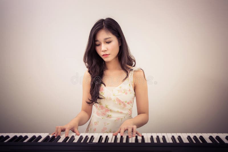 Mujer de Asia que juega el piano imagenes de archivo Mujer de Asia que juega el piano imagenes de archivo
