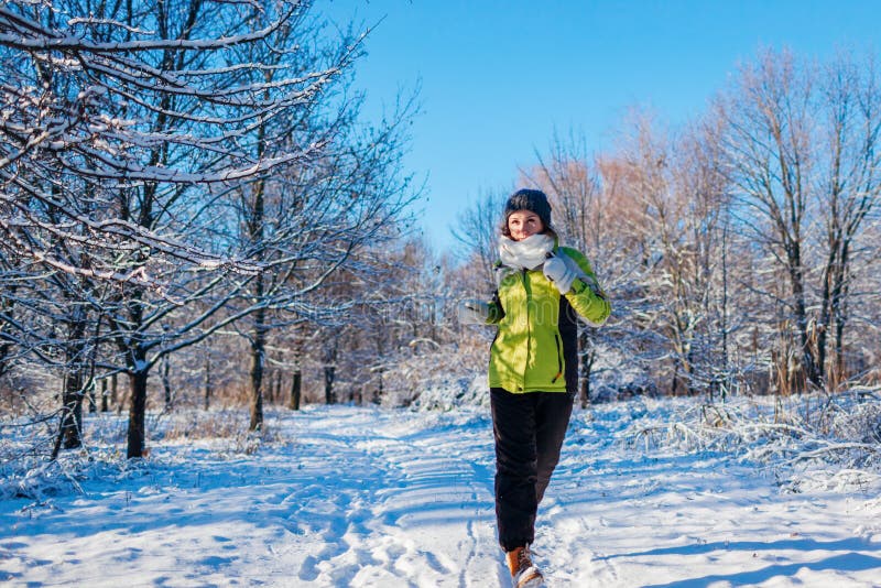 Mujer de funcionamiento del atleta que esprinta en exterior del entrenamiento del bosque del invierno en tiempo nevoso frío fotos de archivo Mujer de funcionamiento del atleta que esprinta en exterior del entrenamiento del bosque del invierno en tiempo nevoso frío fotos de archivo