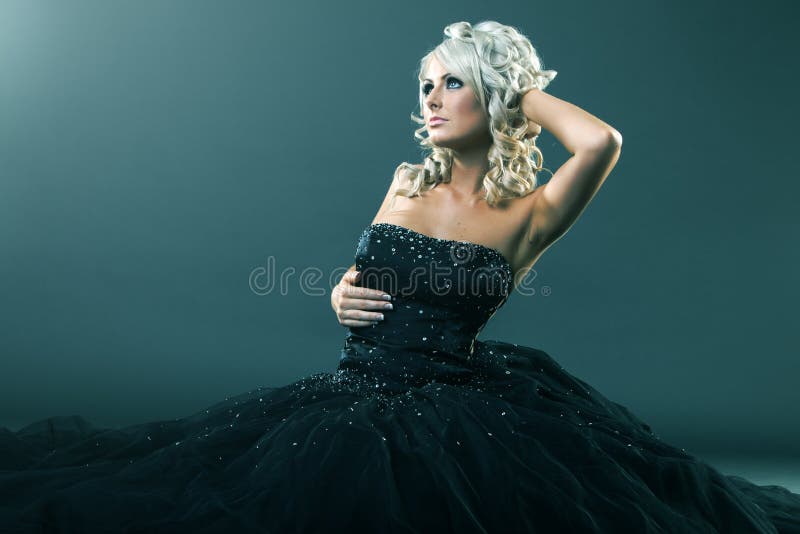 Mujer de la alta moda en actitud atractiva y la sentada grande del vestido formal fotos de archivo libres de regalías Mujer de la alta moda en actitud atractiva y la sentada grande del vestido formal fotos de archivo libres de regalías