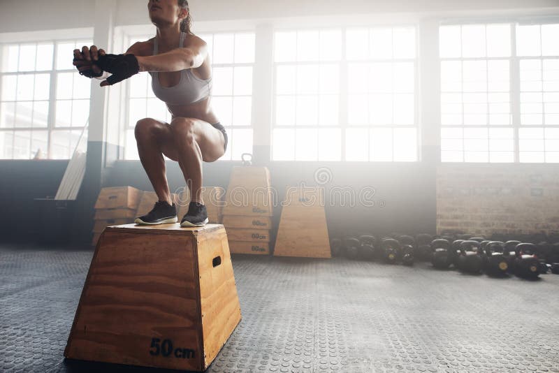 Mujer de la aptitud que hace entrenamiento del salto de la caja en el gimnasio del crossfit fotografía de archivo libre de regalías