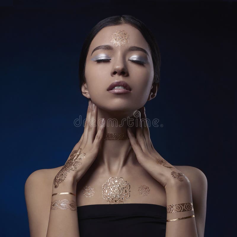 Mujer de la belleza con el modelo de oro de Mehendi fotos de archivo Mujer de la belleza con el modelo de oro de Mehendi fotos de archivo