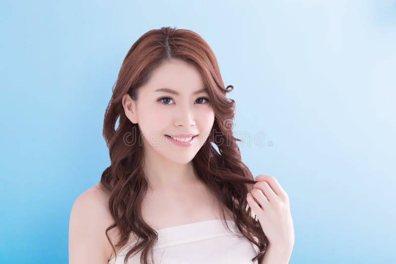 Beauty woman with charming smile to you with health skin, teeth and hair isolated on blue background, asian beauty. Beauty woman with charming smile to you with health skin, teeth and hair isolated on blue background, asian beauty