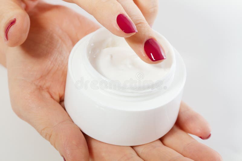 Mujer de la Edad Media que pone la pomada a mano de la botella poner crema aislada en el fondo blanco Balneario y concepto antien imagen de archivo libre de regalías