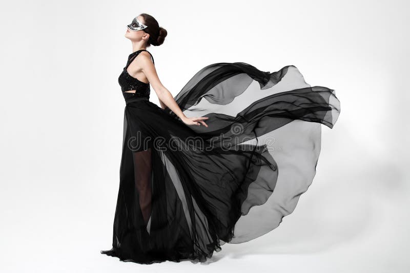 Mujer de la moda en vestido negro que agita Fondo blanco imagen de archivo libre de regalías Mujer de la moda en vestido negro que agita Fondo blanco imagen de archivo libre de regalías