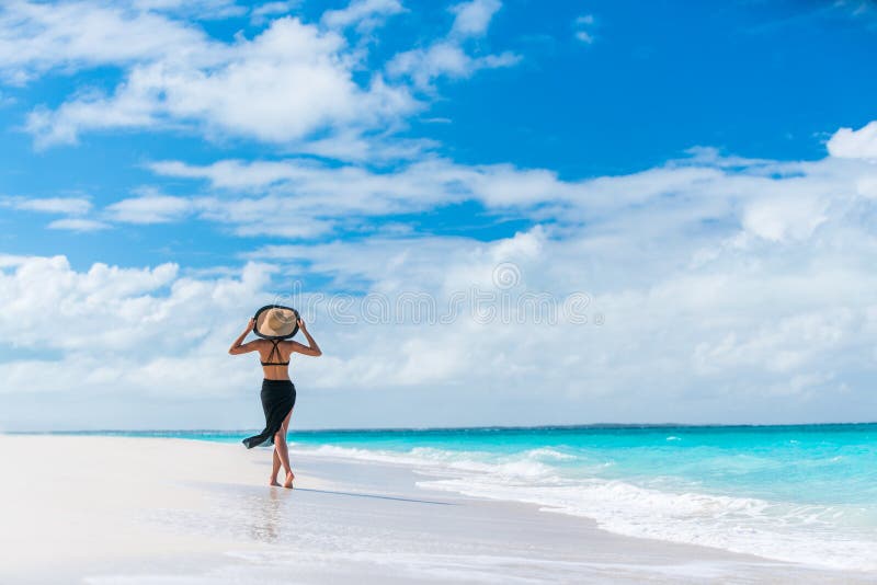 Mujer de lujo de la playa del viaje del verano que camina por el océano