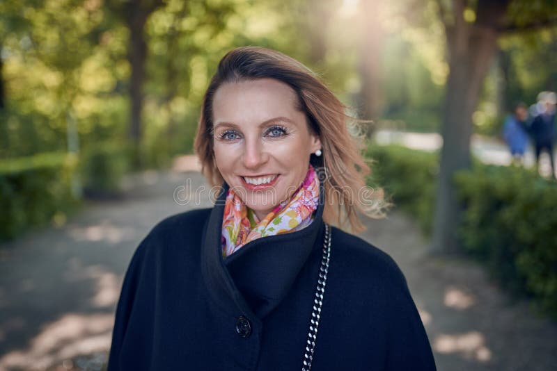 Mujer de mediana edad elegante atractiva con una sonrisa amistosa foto de archivo Mujer de mediana edad elegante atractiva con una sonrisa amistosa foto de archivo