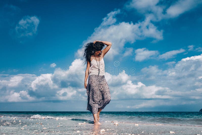 Mujer de moda hermosa que camina en la playa foto de archivo libre de regalías Mujer de moda hermosa que camina en la playa foto de archivo libre de regalías