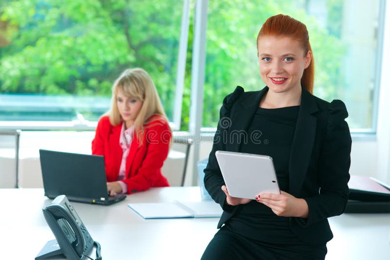 Mujer de negocios atractiva en oficina con la tableta fotos de archivo Mujer de negocios atractiva en oficina con la tableta fotos de archivo
