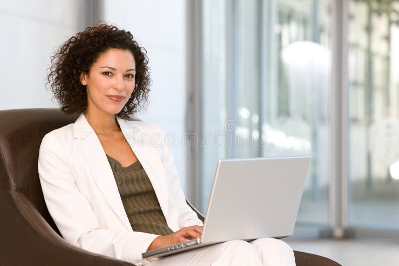 Mujer de negocios atractiva que trabaja en la computadora portátil