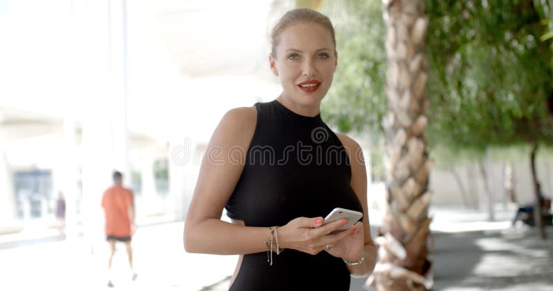 Mujer de negocios bonita que usa el teléfono celular metrajes