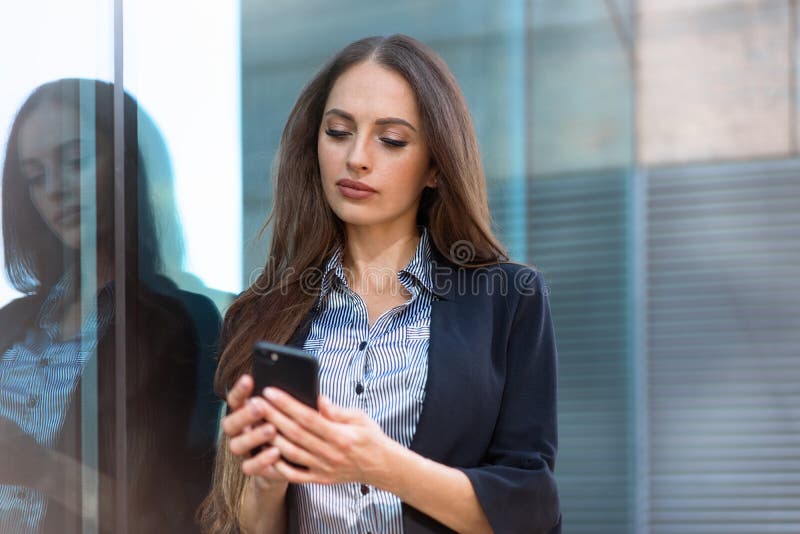 Mujer De Negocios Camiseta De Rayas De 35 Años Y Chaqueta Negra De Pelo Largo Parada Cerca Del De Oficinas Uso Smartphone Foto de archivo - Imagen de serio, empresario: 242010606