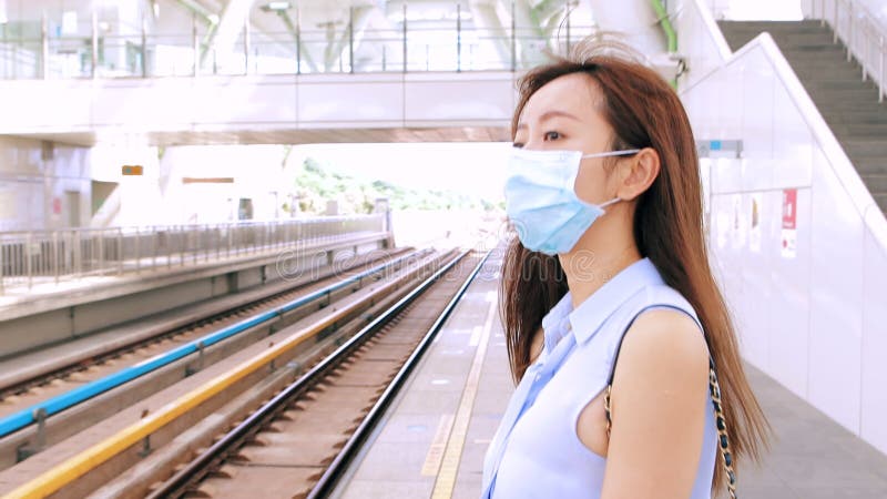 Mujer de negocios con máscara facial en la estación de tren metrajes