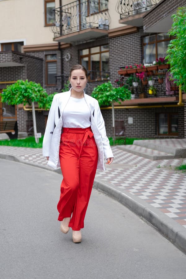 Mujer De Negocios Con Pantalones Rojos Blusa Y Chaqueta Caminando Por La Foto de archivo - Imagen de urbano, ciudad: 228390902
