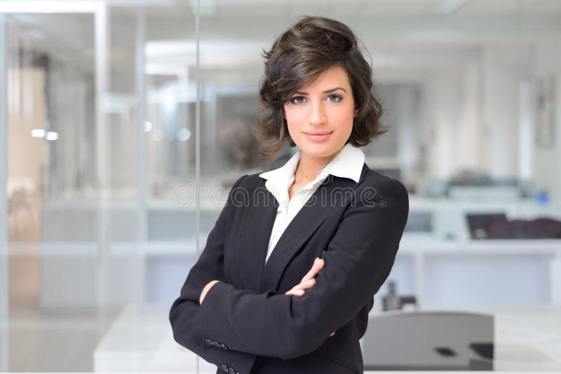 Mujer de negocios en una oficina. Brazos cruzados fotografía de archivo libre de regalías Mujer de negocios en una oficina. Brazos cruzados fotografía de archivo libre de regalías
