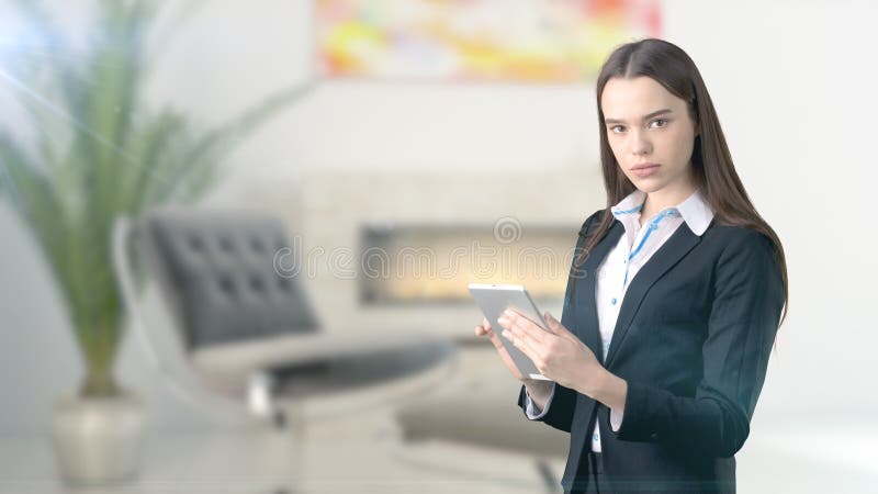 Mujer de negocios hermosa joven y diseñador creativo que se colocan sobre fondo interior blured fotografía de archivo libre de regalías Mujer de negocios hermosa joven y diseñador creativo que se colocan sobre fondo interior blured fotografía de archivo libre de regalías