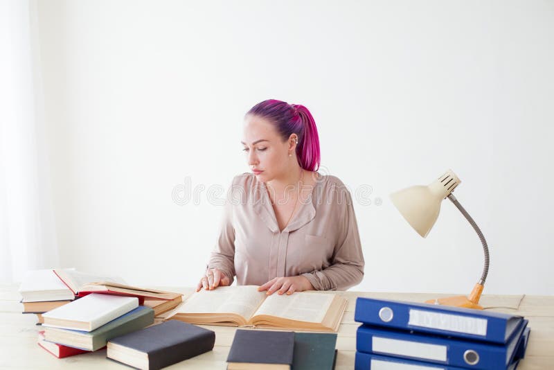Mujer de negocios hermosa que trabaja en una oficina detrás de una tabla con los libros imágenes de archivo libres de regalías Mujer de negocios hermosa que trabaja en una oficina detrás de una tabla con los libros imágenes de archivo libres de regalías
