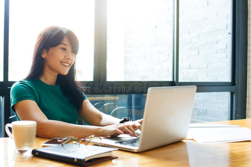 Mujer de negocios joven asiática del dueño que trabaja en línea, comprobando el correo en proceso de trabajo de organización del Mujer de negocios joven asiática del dueño que trabaja en línea, comprobando el correo en proceso de trabajo de organización del