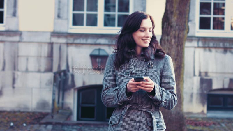 Mujer de negocios joven con smartphone fuera de la oficina