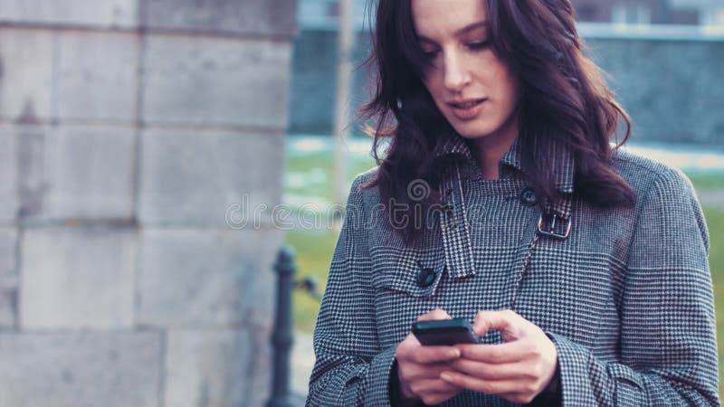 Mujer de negocios joven con smartphone fuera de la oficina