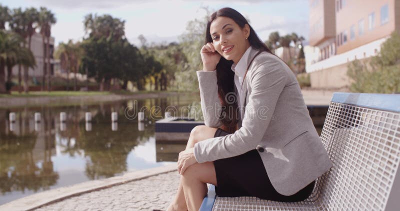 Mujer de negocios magnífica que se sienta en banco almacen de video