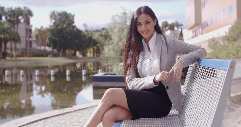 Mujer de negocios magnífica que se sienta en banco almacen de video