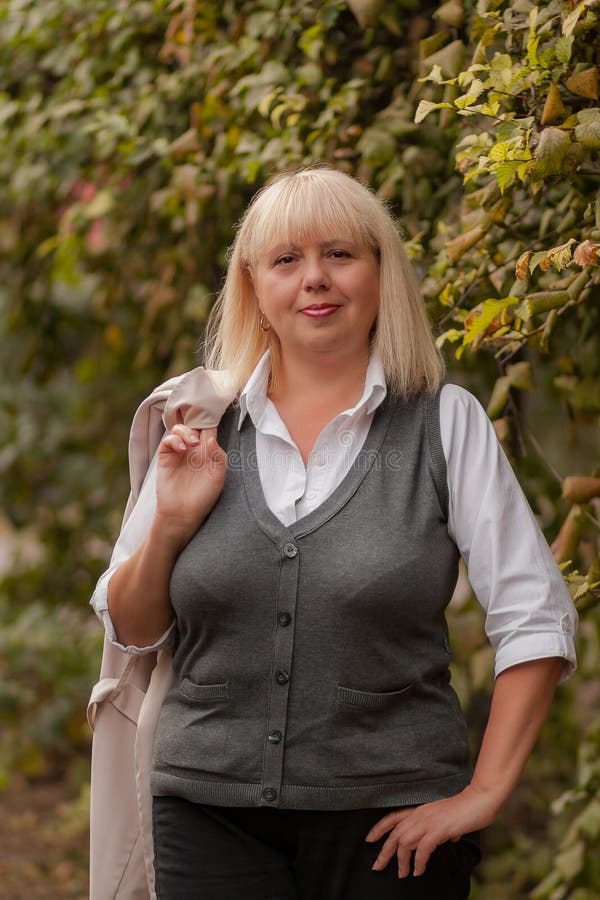 Mujer De Negocios Mayor Que Camina En El Parque Del Otoño Una Mujer En Un  Estilo Clásico De La Ropa Mujer Elegante En Un Traje Mu Imagen de archivo -  Imagen de