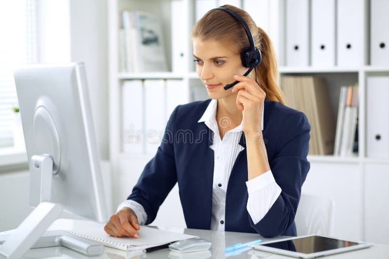 Mujer de negocios moderna con las auriculares en la oficina Lugar de trabajo del operador del servicio de atención al cliente en