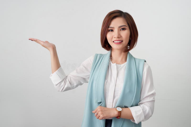 Mujer de negocios que presenta el producto en su mano aislada en blanco foto de archivo Mujer de negocios que presenta el producto en su mano aislada en blanco foto de archivo