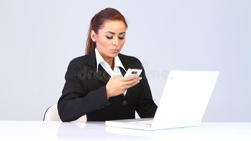 Mujer de negocios que se sienta en el escritorio y el teléfono que habla almacen de metraje de vídeo