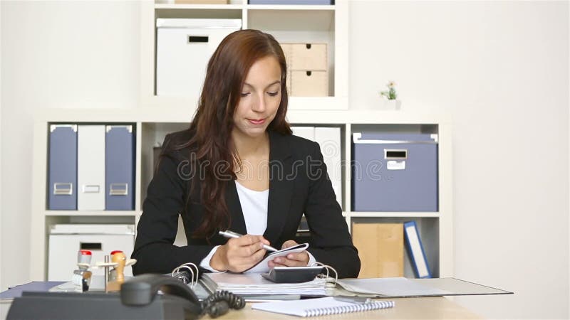 Mujer de negocios que trabaja en su escritorio almacen de metraje de vídeo