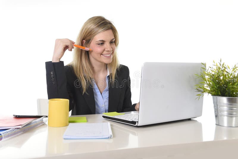Mujer de negocios rubia feliz que trabaja en el ordenador en la sonrisa del escritorio de oficina imágenes de archivo libres de regalías Mujer de negocios rubia feliz que trabaja en el ordenador en la sonrisa del escritorio de oficina imágenes de archivo libres de regalías